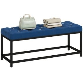 Banco pie de cama tapizado en terciopelo azul oscuro con base de metal y diseño capitoné
